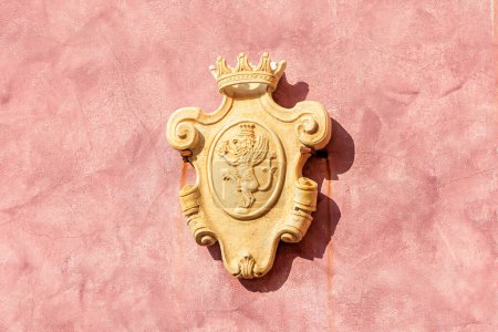 Foto de Cartel de escudo de oro en la ciudad croata Rovinj con león alado veneciano como animal heráldico en la pared roja - Imagen libre de derechos