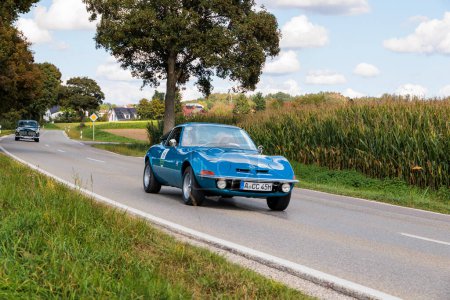 Foto de Blue Opel GT Coupe from the 70 's driving on a country road near Blumenthal Castle during the classic car rally Fuggerstadt Classics, Alemania, Augsburg, 24 de septiembre de 2023 - Imagen libre de derechos