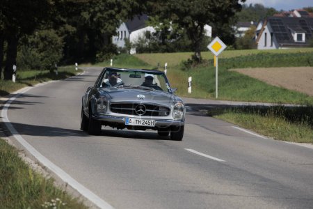 Foto de Silver Mercedes Benz 230 SL Pagode W113 from the 60's driving on a country road near Blumenthal Castle during the classic car rally Fuggerstadt Classics, Germany, Augsburg, September 24, 2023 - Imagen libre de derechos