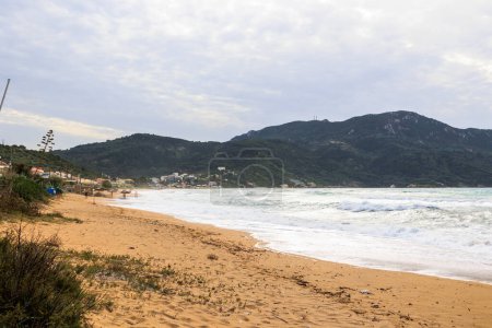Foto de La playa de arena de Agios Georgios en la isla de Corfú en un día tormentoso con olas altas - Imagen libre de derechos