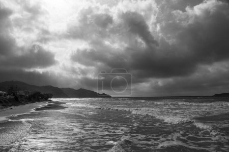 Téléchargez les photos : Côte de l'île de Corfou près de la ville d'Arillas sous un ciel nuageux et une mer lourde - en image libre de droit