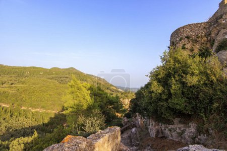 Téléchargez les photos : Ruines du château Angelokastro dans la soirée sous un ciel bleu sur l'île de Corfou - en image libre de droit