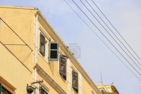 Téléchargez les photos : Immeuble résidentiel avec lignes électriques aériennes et antennes dans la vieille ville de Corfou sur l'île de Corfou - en image libre de droit