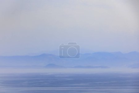 Téléchargez les photos : Vue de l'île de Corfou en Grèce sur la mer à la côte albanaise image minimaliste avec un faible contraste - en image libre de droit