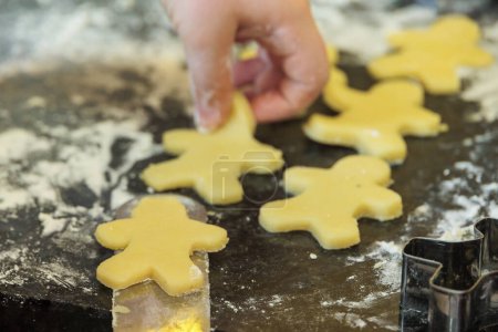 Photo for Children's hands cut out Christmas biscuits from sweet dough before Christmas - Royalty Free Image