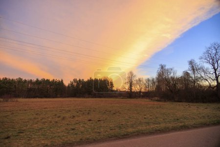 Foto de Colorida banda de nubes en el cielo matutino sobre los campos y prados de Siebenbrunn, el distrito más pequeño de la ciudad de Fugger de Augsburgo - Imagen libre de derechos