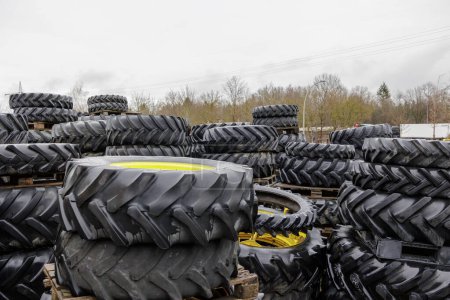 Foto de Ruedas y neumáticos de tractores usados apilados en paletas - Imagen libre de derechos