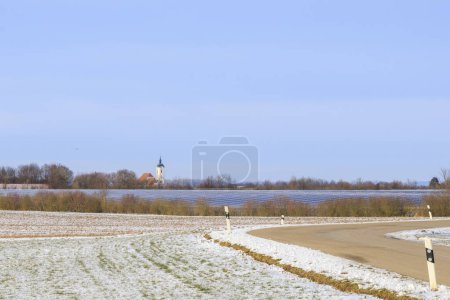 Foto de Módulos fotovoltaicos en un campo cerca de Dunzelbach en una zona rural de Baviera en Alemania en un día de invierno con campos cubiertos de nieve - Imagen libre de derechos