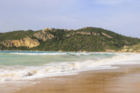 La playa de arena de Agios Georgios en la isla de Corfú en un día tormentoso con olas altas