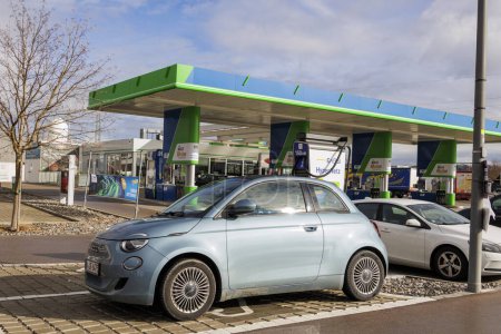 Photo for Blue Fiat500 convertible with sunroof at an ENBW fast charging station at the OMV petrol station in Derching near Augsburg, Germany, 14 February 2024 - Royalty Free Image