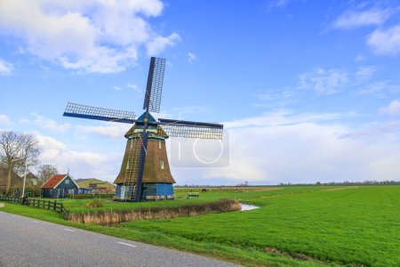 Foto de Un molino de viento holandés típico como un molino de pólder con rueda de paleta para drenar los pólderes en los Países Bajos cerca de la ciudad de Schagen - Imagen libre de derechos