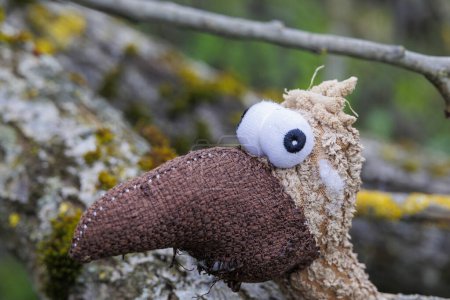 Soft toy bird on a tree trunk in the Durrenast Heath in the city forest of the Fugger city of Augsburg