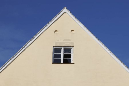 Giebel eines Hauses mit zerbrochener Fensterscheibe unter blauem Himmel in Wellenburg bei Augsburg