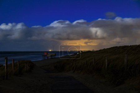 Téléchargez les photos : Dunes sur la plage près du monument Pettendorf aux Pays-Bas la nuit avec une pleine lune - en image libre de droit
