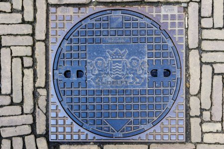 Photo for Manhole cover with the coat of arms of the city of Delft in the Netherlands, Delft, 25 March 2024 - Royalty Free Image