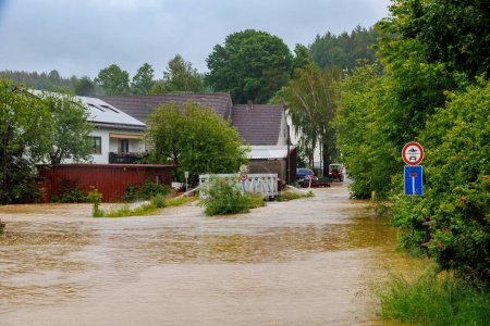 Flooded bridge and buildings  due to flooding of the Schwarzach stream in Germany, Bobingen Waldberg , 1 June 2024