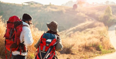 Téléchargez les photos : Couple voyageur avec sac à dos debout vue sur la montagne - en image libre de droit
