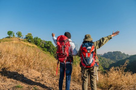 Téléchargez les photos : Couple voyageur avec sac à dos debout vue sur la montagne - en image libre de droit