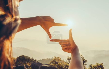 Téléchargez les photos : Close up hand framing looking view sunrise - en image libre de droit