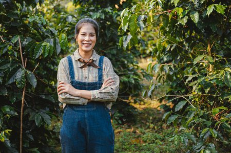 Téléchargez les photos : Jeune femme debout avec sourire à la ferme de café - en image libre de droit