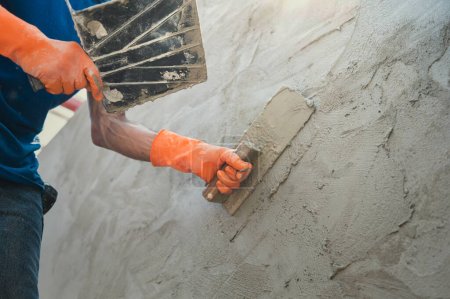 Photo for Closeup hand of worker plastering cement at wall for building house - Royalty Free Image