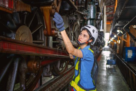 Téléchargez les photos : Ingénieur femelle vérifiant l'équipement en usine pour réparation - en image libre de droit