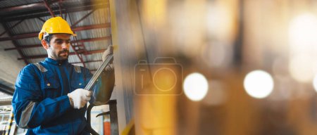 Téléchargez les photos : Travailleur homme vérification et l'utilisation de clé pour la machine métallique d'entretien à l'usine - en image libre de droit