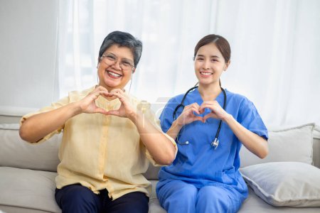 Téléchargez les photos : Infirmière avec patient âgé montrant un coeur de main montrant une amélioration de la santé par rapport au traitement en salle. - en image libre de droit
