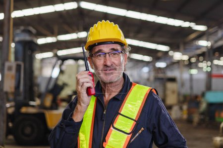 Téléchargez les photos : Ingénieur utiliser talkie walkie à l'usine de machines - en image libre de droit
