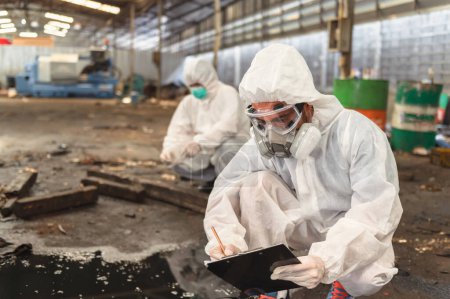 Chemiespezialist trägt Schutzuniform und Gasmaske bei der Überprüfung von Chemikalienlecks in Industriewerk