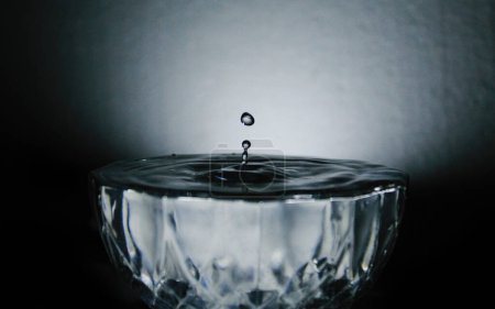 Perfekt gefangenes Wasser Tropfen oder Sprinkle, fallen in Schüssel mit Wasser beladen.