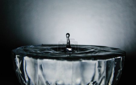 Perfekt gefangenes Wasser Tropfen oder Sprinkle, fallen in Schüssel mit Wasser beladen.