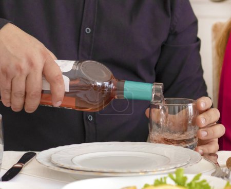 Foto de Young man pouring wine from the bottle into a glass . wine at restaurant. High quality photo - Imagen libre de derechos