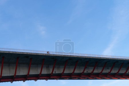 Photo for Puente de los Santos, with cyclist. Border of Asturias and Galicia, Spain. View from below with sky background with some clouds. Space copy. - Royalty Free Image