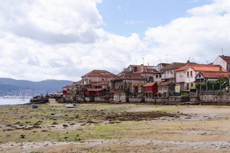 Blick auf die Stadt Combarro in Galicien vom Ufer der Mündung aus. Landschaft mit wolkenverhangenem Himmel und das Dorf an der Mündung.