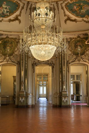 Foto de Queluz, Lisboa, Portugal- 17 de enero de 2023: Lámparas de araña de cristal, muebles y refinada decoración de madera dorada del hermoso Palacio Nacional de Queluz, Sintra - Imagen libre de derechos