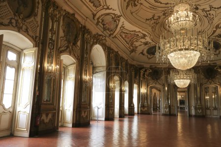 Foto de Queluz, Lisboa, Portugal- 17 de enero de 2023: Lámpara de araña de cristal, muebles y decoración de madera dorada refinada del hermoso Palacio Nacional de Queluz, Sintra - Imagen libre de derechos