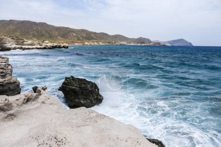 Foto de Olas rompiendo rocas de colores en la playa de Los Escullos, Almería, Cabo de Gata - Imagen libre de derechos