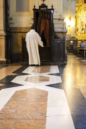 Téléchargez les photos : Saragosse, Espagne- 14 août 2023 : Prêtre entrant au confessionnal avec rideau rouge - en image libre de droit