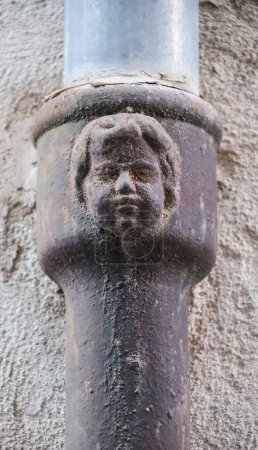 Gesicht auf einer alten, geschmiedeten Metallrinne in Alcoy, Alicante. Moderner Stil