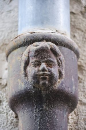 Gesicht auf einer alten, geschmiedeten Metallrinne in Alcoy, Alicante. Moderner Stil