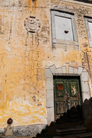 Maison ancienne avec façade déchiquetée colorée et lampadaire à Elvas, Portugal