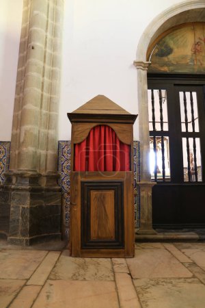 Téléchargez les photos : Elvas, Portugal- 14 octobre 2023 : Vieux confessionnaux en bois avec rideau rouge dans la cathédrale Notre-Dame de l'Assomption à Elvas - en image libre de droit