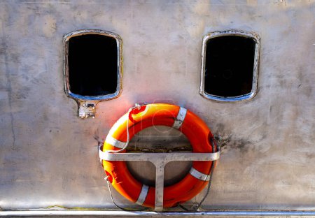 Window and orange lifebuoy of boat forming a conceptual image of a sad face