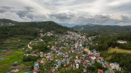 Téléchargez les photos : Ville de Sagada dans la vallée au milieu des montagnes couvertes de forêt. Philippines. - en image libre de droit