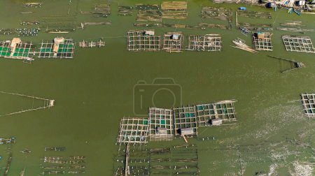 Téléchargez les photos : Ferme piscicole sur la rivière et un village avec pêcheurs. Rivière Hinigaran. Negros, Philippines - en image libre de droit