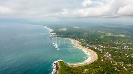 The coast with a beach and hotels among palm trees. Dickwella Beach, Sri Lanka.