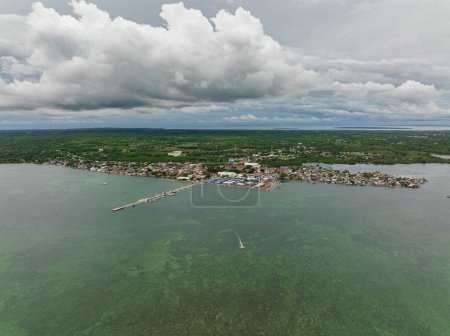 Photo for A town on the seashore with a pier and fishermens houses. Bantayan Island. Philippines. - Royalty Free Image