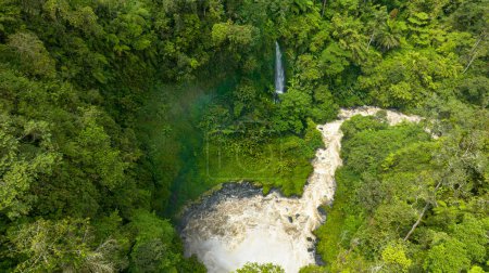 Aerial view of river and waterfall among the tropical jungle. Sumatra, Jambi, Indonesia.