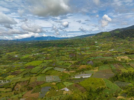 Photo for Top view of mountain landscape with green hills and farmland. Kayu Aro, Sumatra, Indonesia. - Royalty Free Image